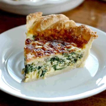 slice of spinach quiche on plate.