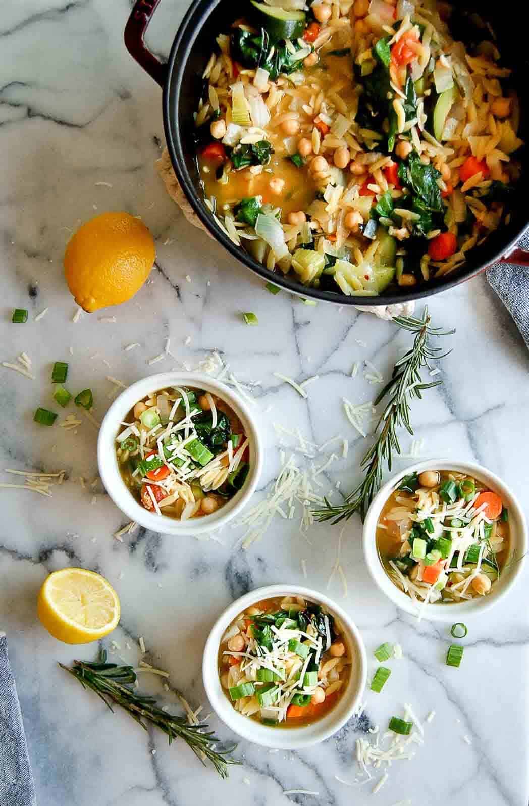 large pot filled with chickpea soup with small bowls scattered around it.