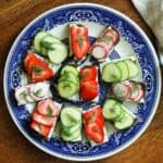 cucumber tea sandwiches, strawberry tea sandwiches, and radish tea sandwiches on platter.