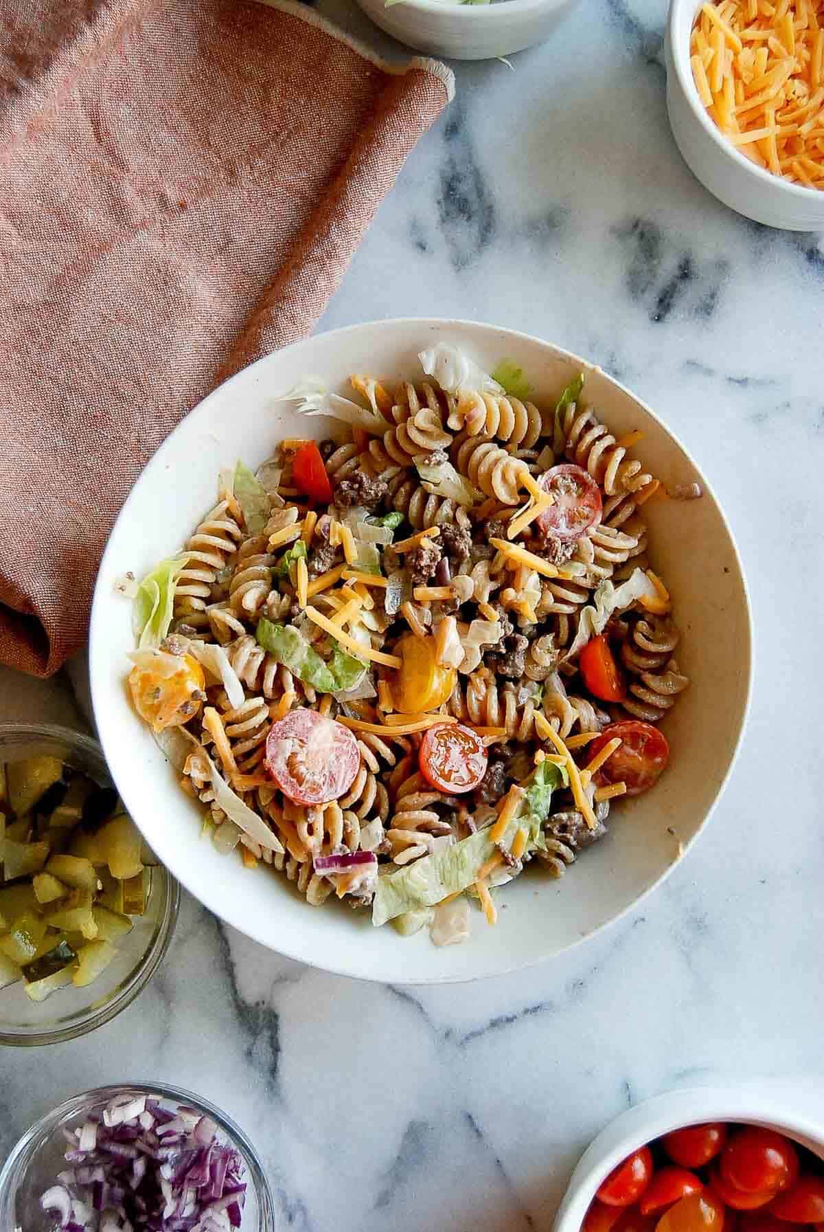 Jimmy Buffett Pasta salad in bowl with other ingredients scattered around.