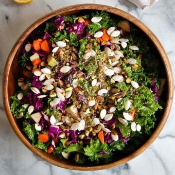 kale crunch salad with crunchy toppings in bowl.