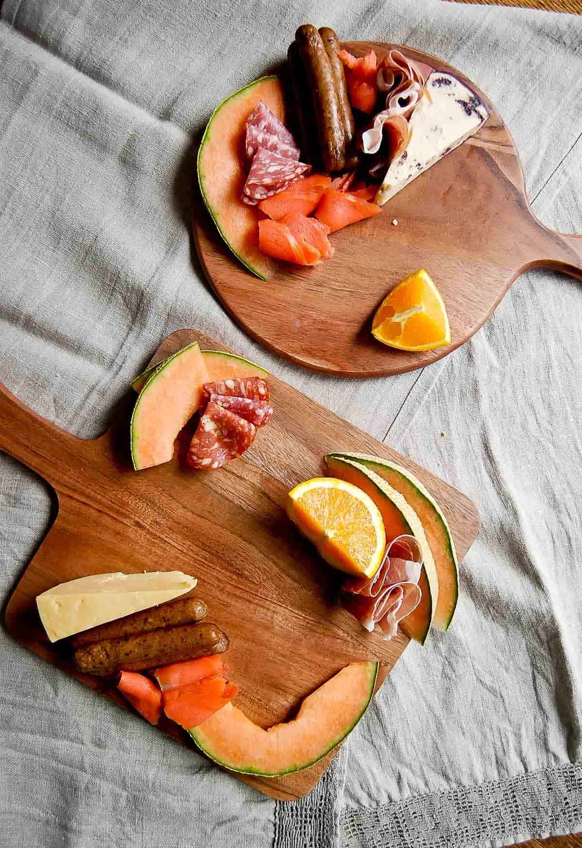 serving board with cheese, fruit and meats.