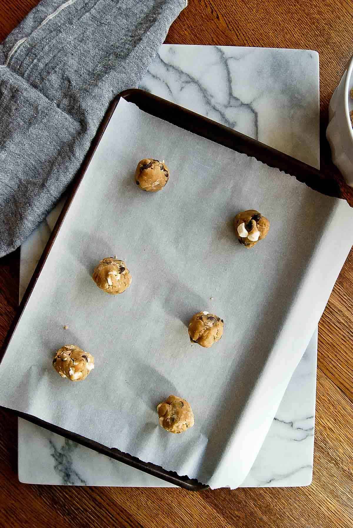 6 dough balls of chocolate chip marshmallow cookies.