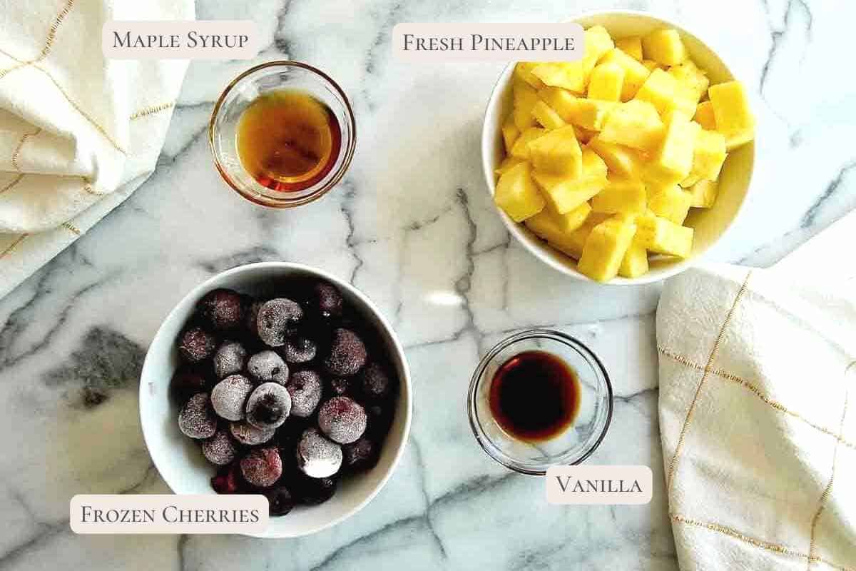 ingredients for pineapple and cherry popsicles on a countertop.