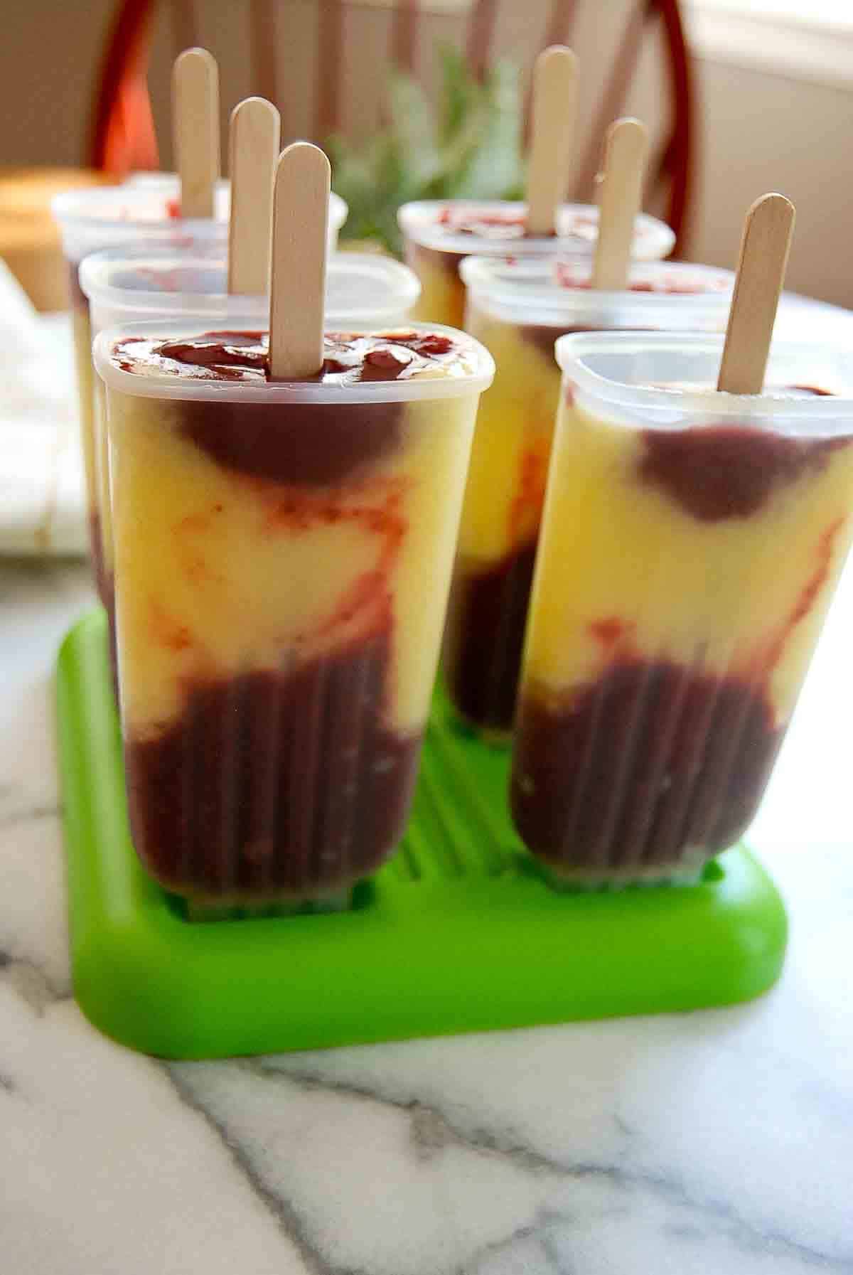 fruit popsicles in popsicle mold with sticks.