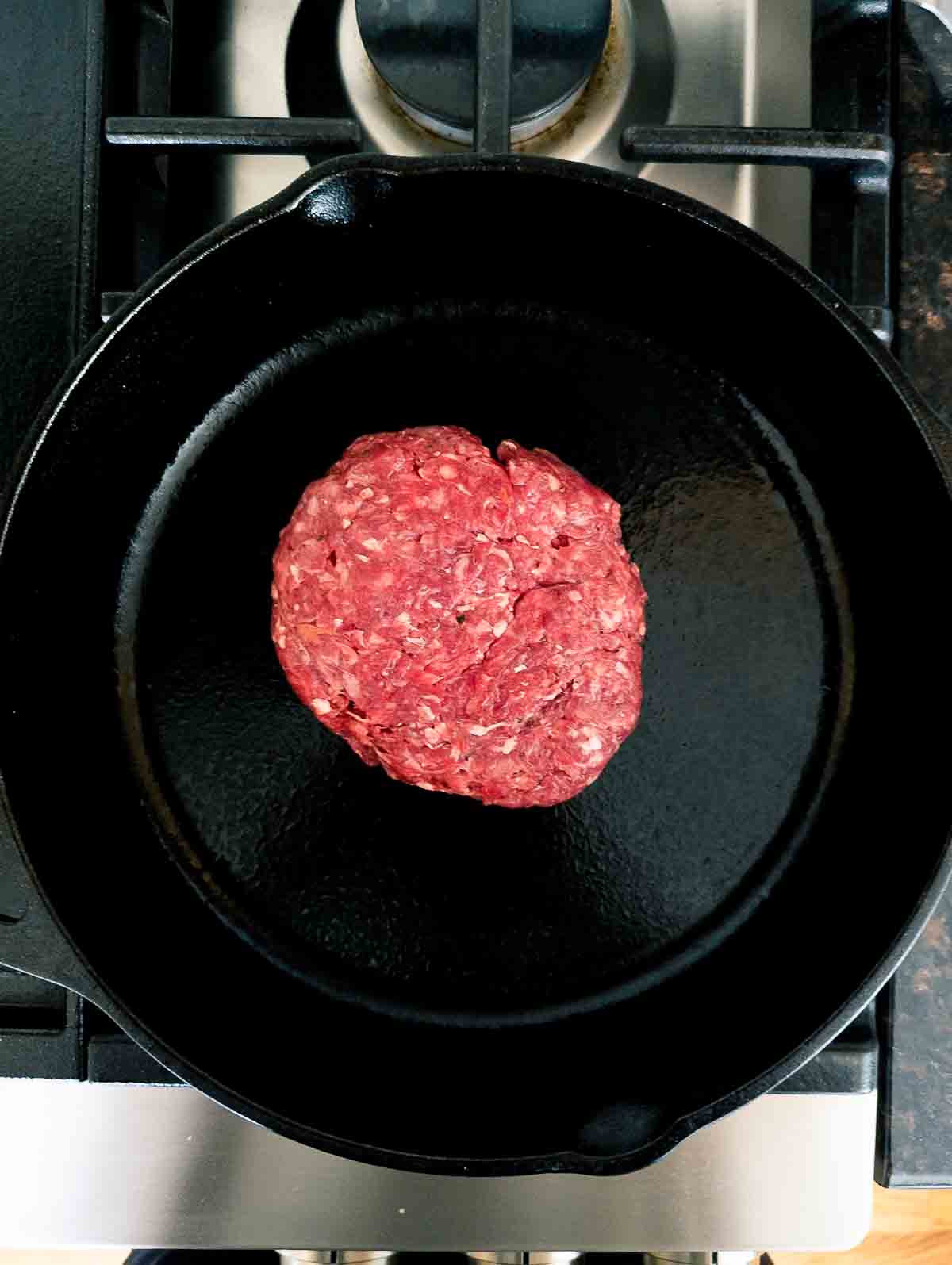 smashed burger in cast iron skillet.