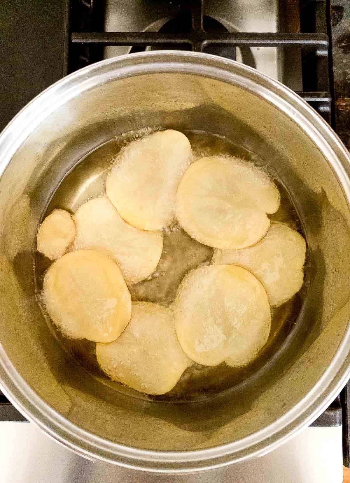 potato slices frying in hot oil.