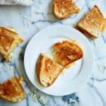 closeup of crispy sourdough grilled cheese on plate.
