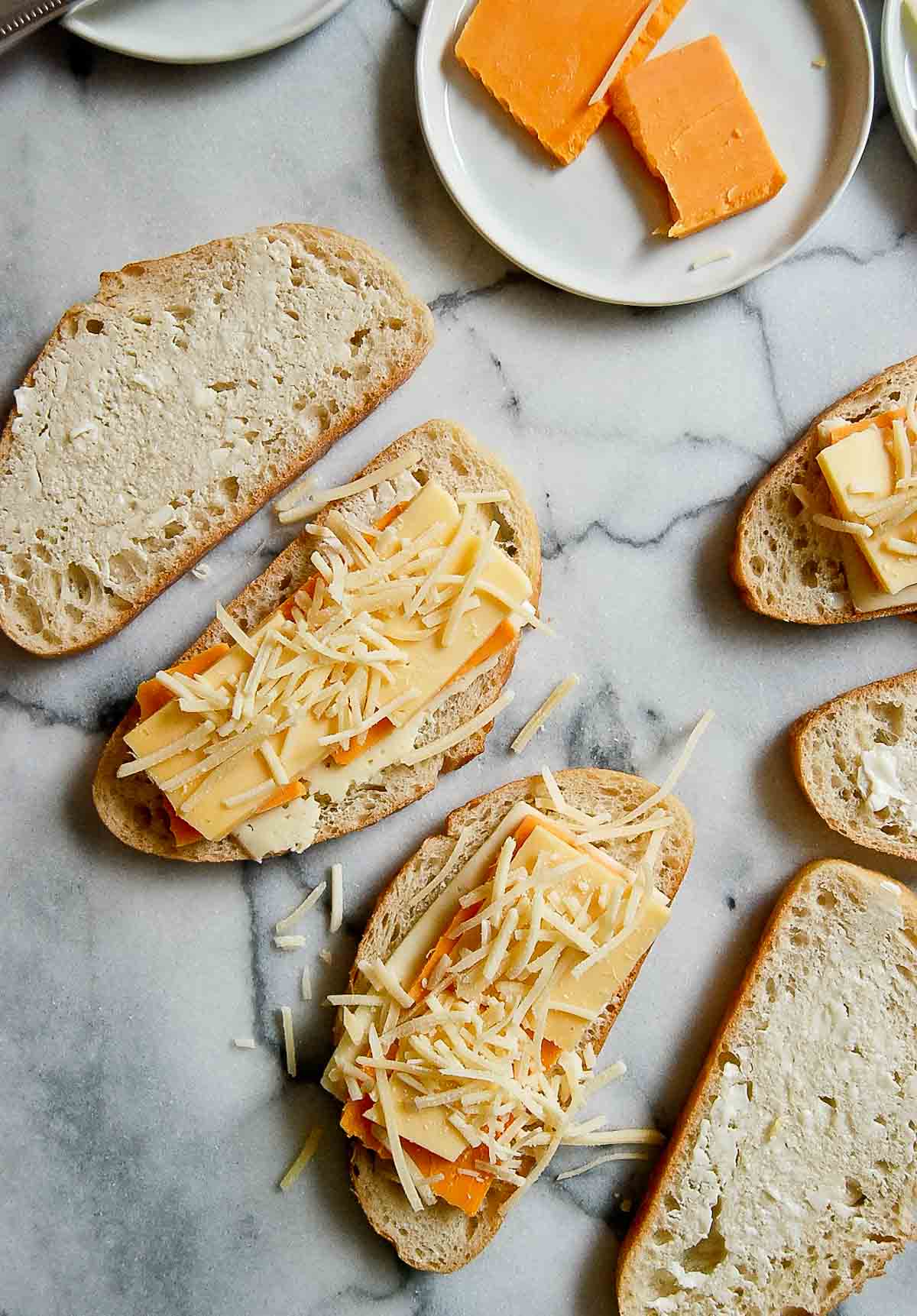 close up of buttered sourdough bread with cheese slices on top.