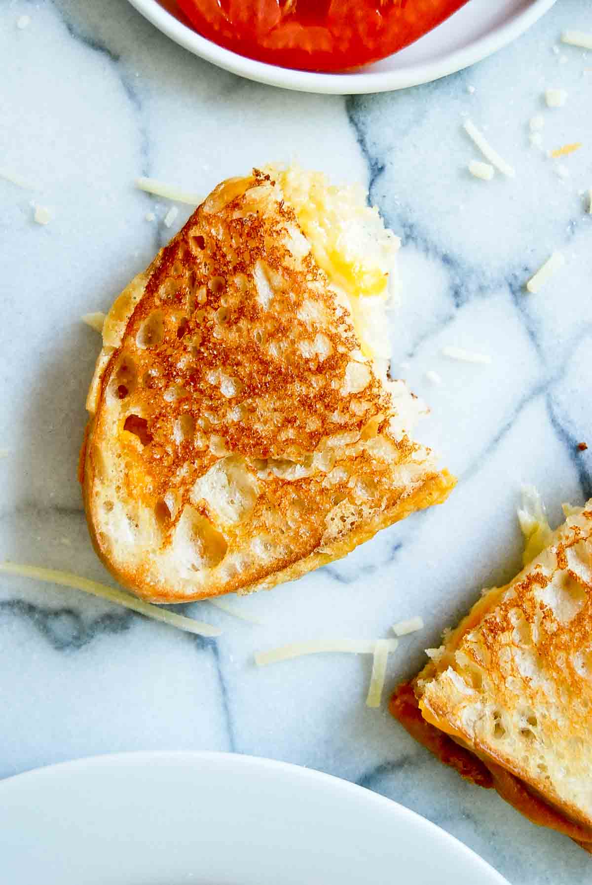 half of a crispy sourdough grilled cheese sandwich.