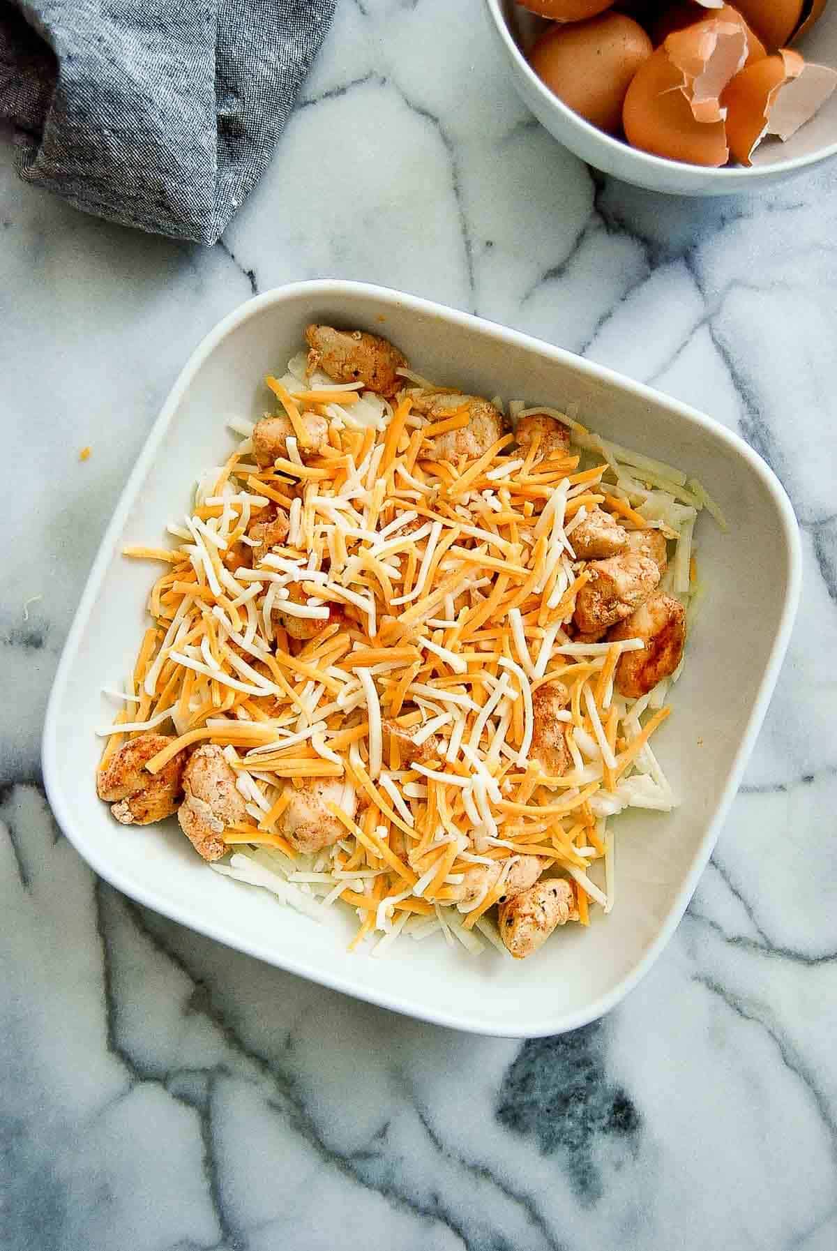 hash browns, chicken and cheese in casserole bowl.