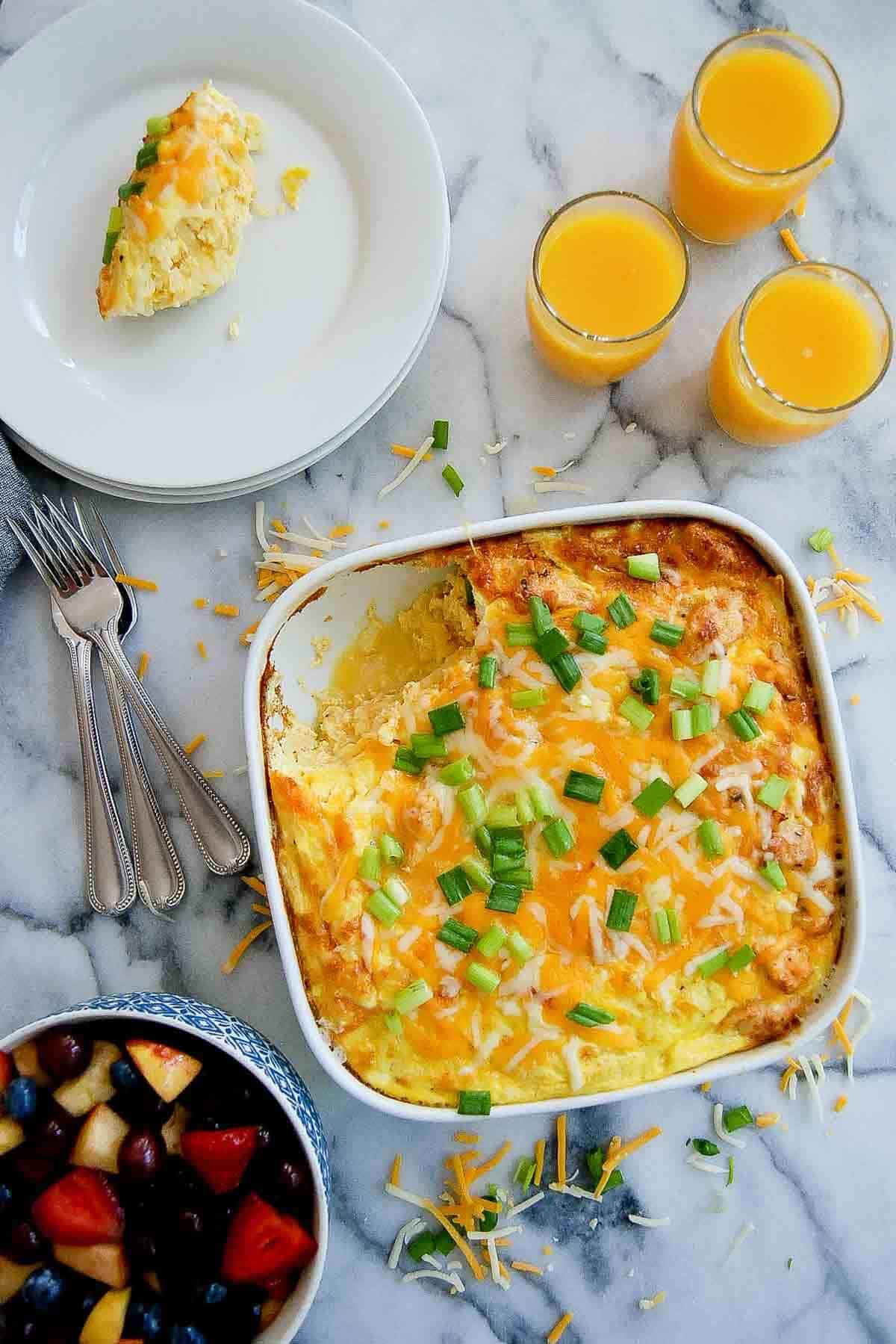cheesy chicken, hash brown, and egg breakfast casserole in dish with one piece on plate.