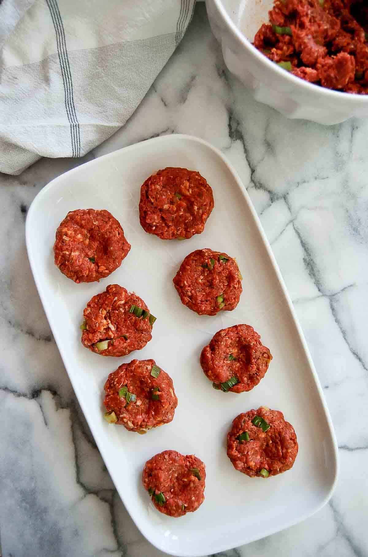 spanish slider patties - pre cooked, on tray.