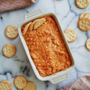 hot cajun crab dip in baking dish with ritz crackers.