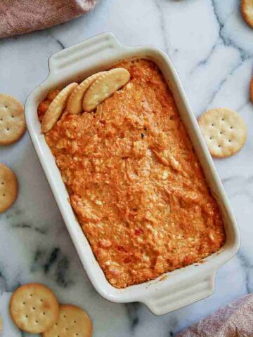 hot cajun crab dip in baking dish with ritz crackers.