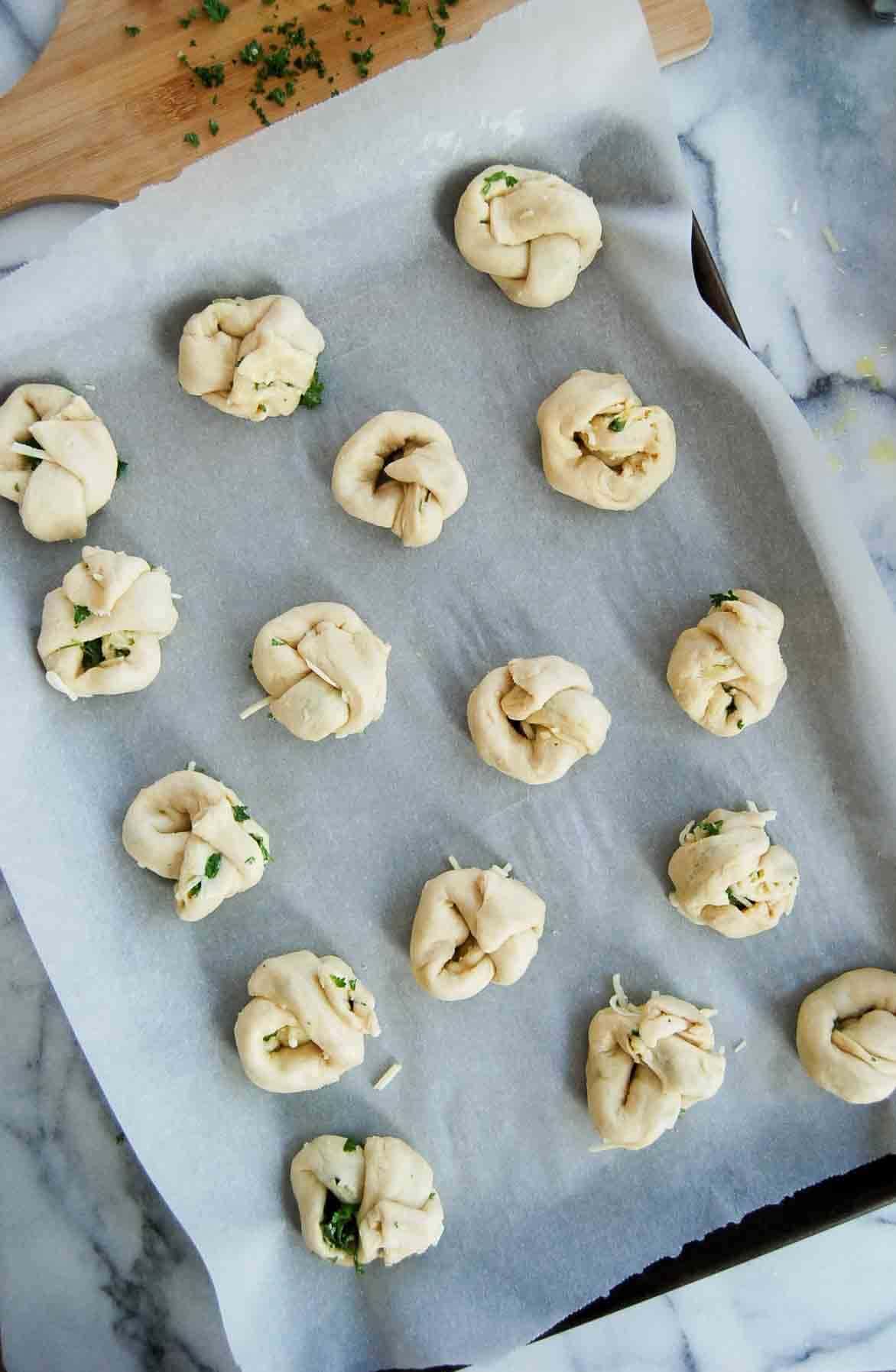 crescent roll garlic knots on baking sheet.