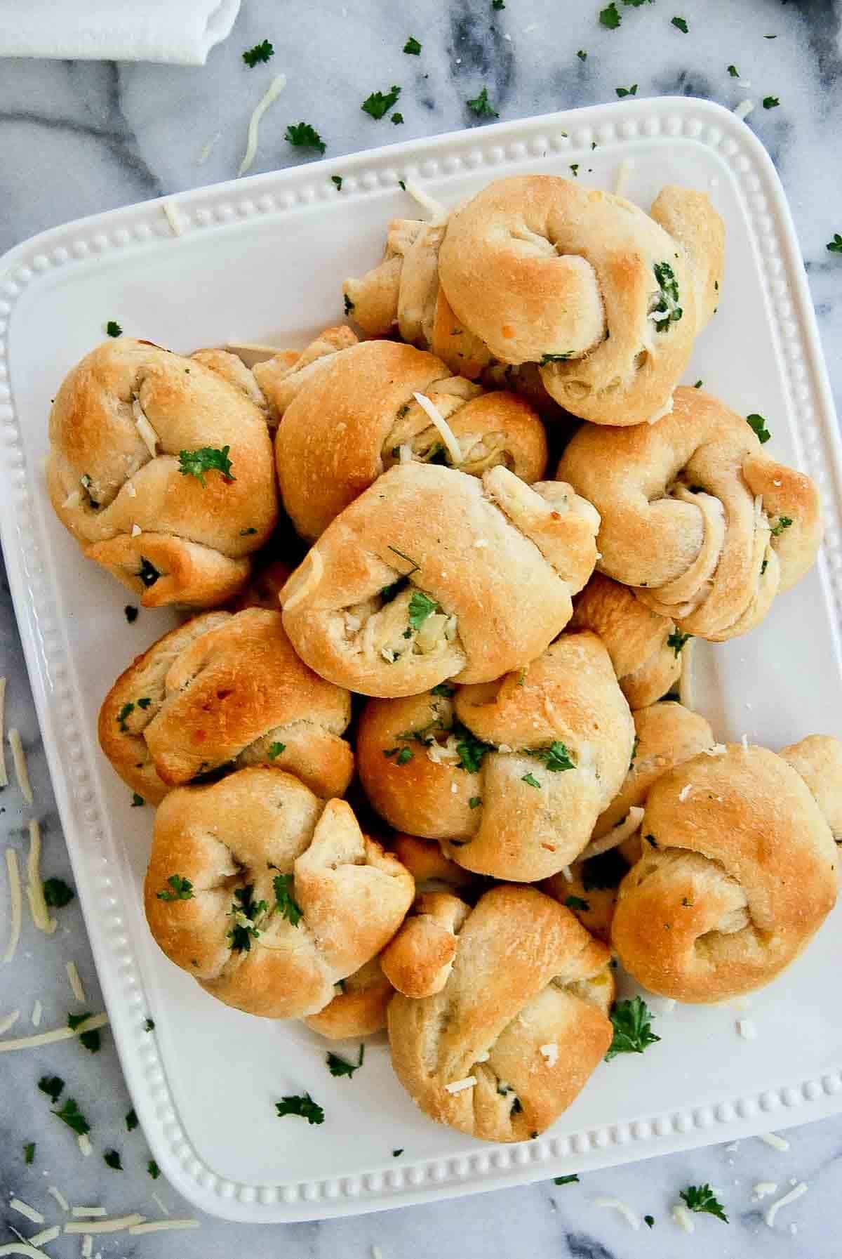 closeup of buttery garlic knots on platter.