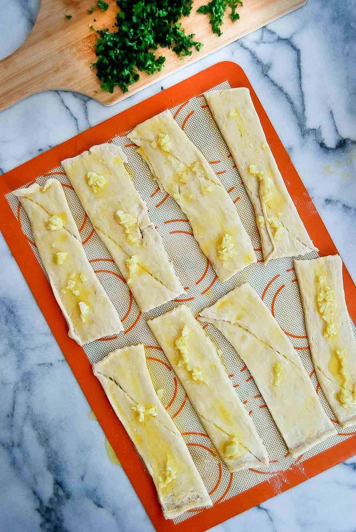 crescent roll dough strips with garlic butter.