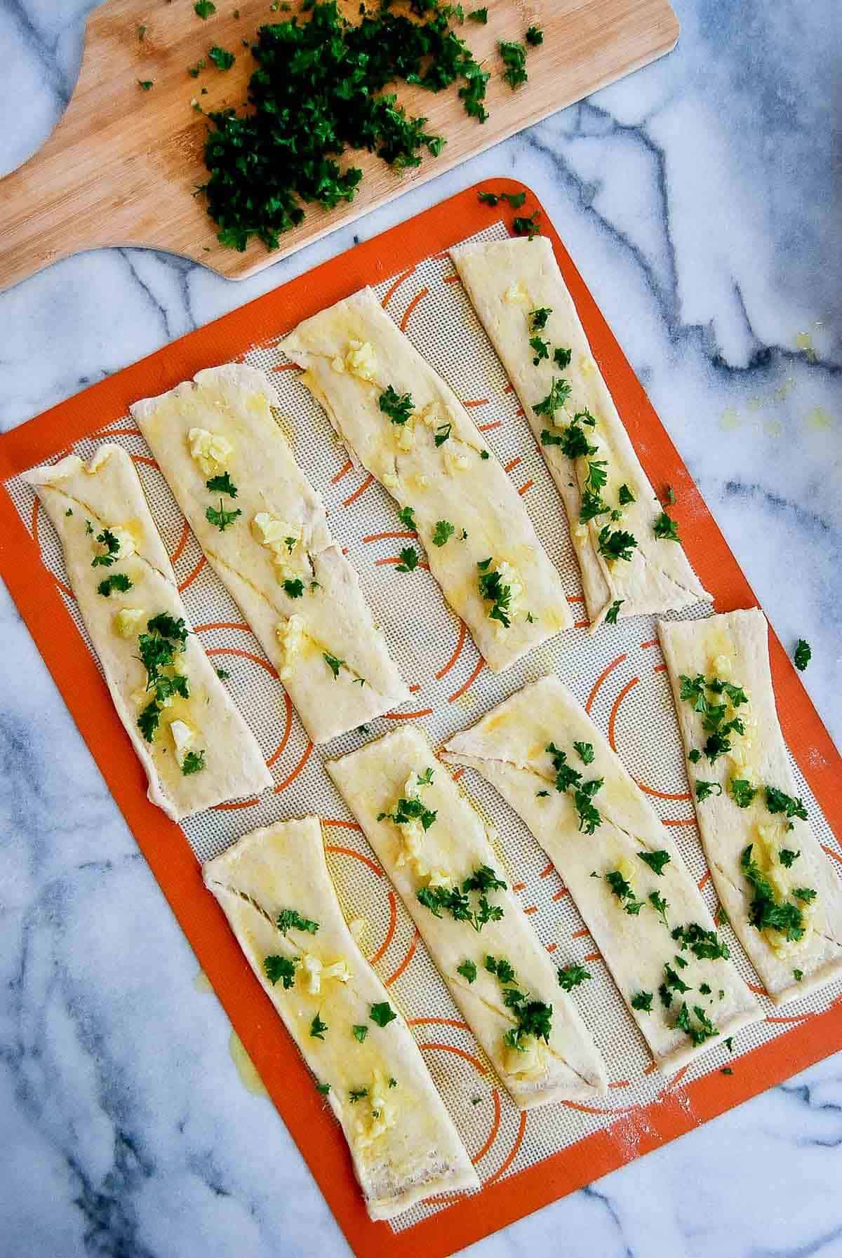 crescent roll dough strips with garlic butter and herbs.