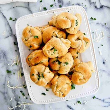 crescent roll garlic knots on serving plate.