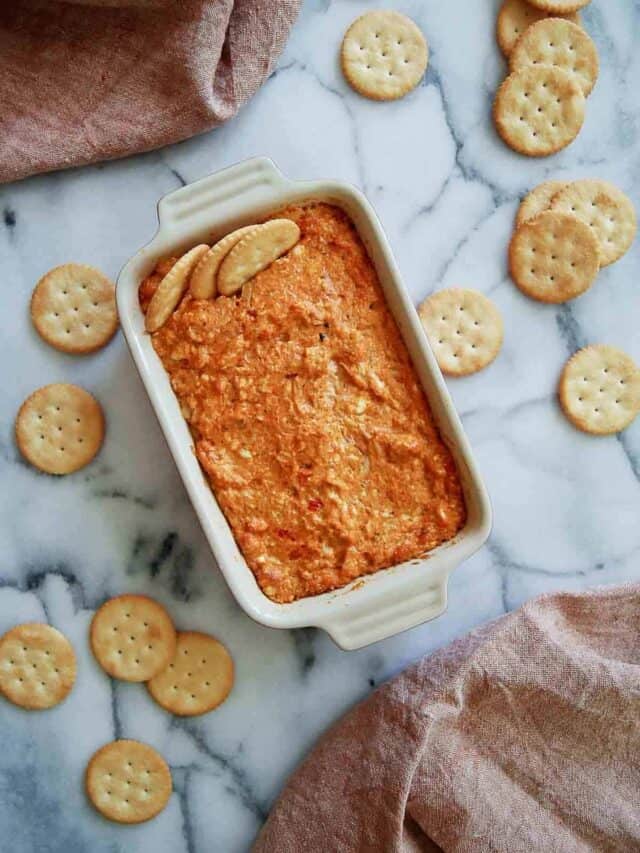 hot cajun crab dip in baking dish with ritz crackers.
