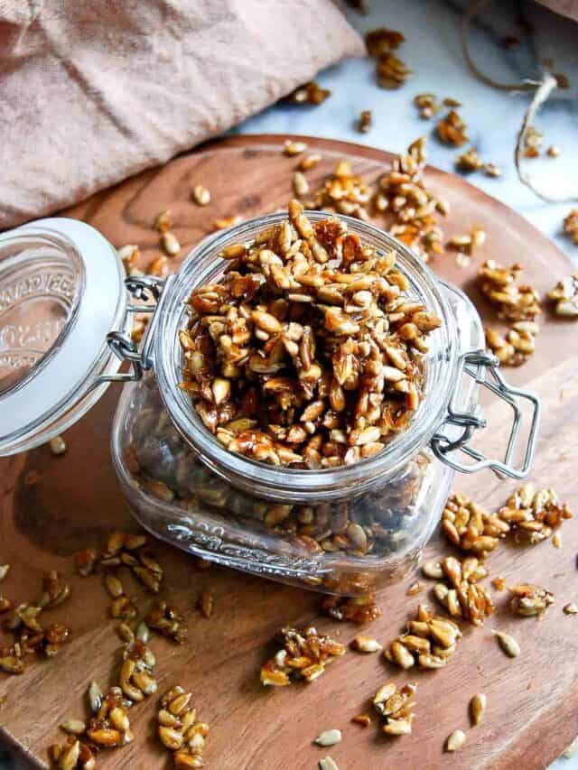 closeup of honey coated sunflower seeds in jam jar.