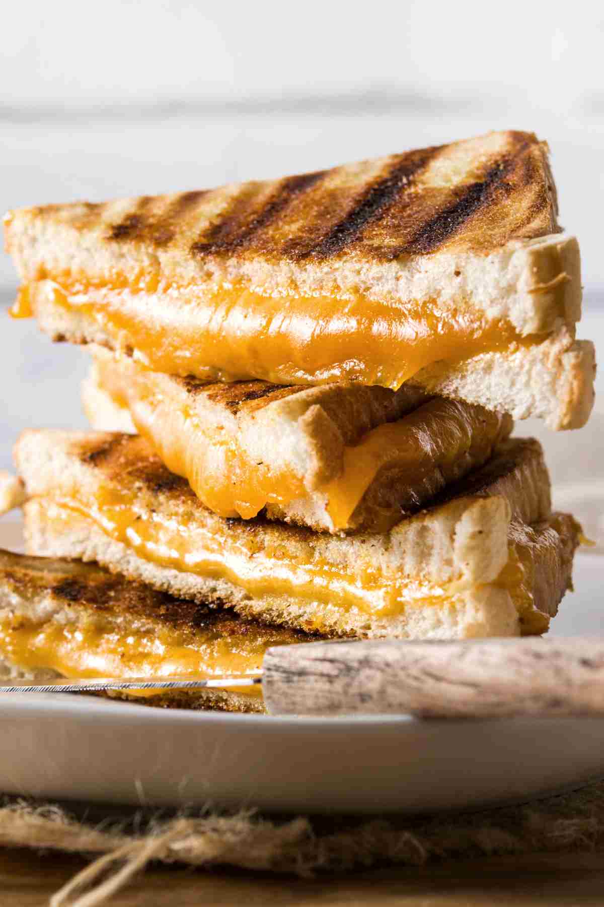 grilled cheese halves stacked on a plate.