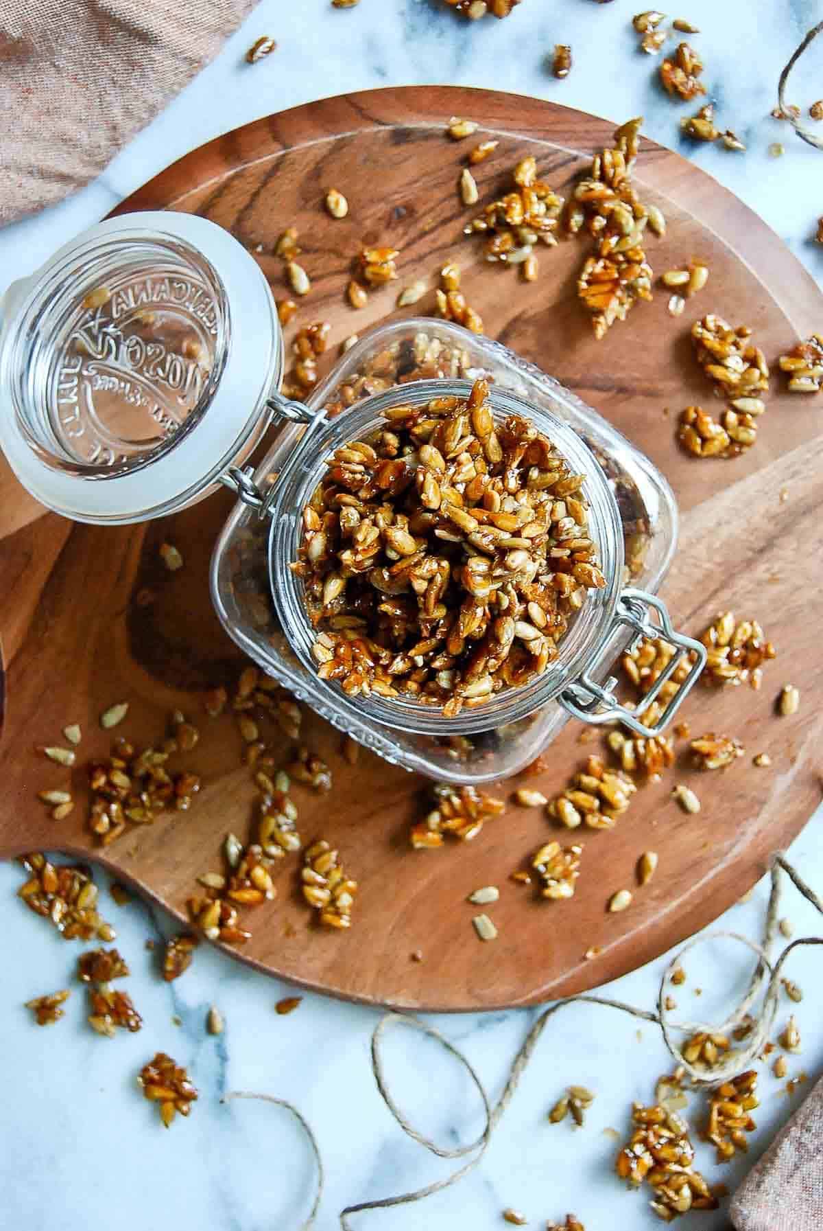 honey roasted sunflower seeds in jam jar on cutting board.