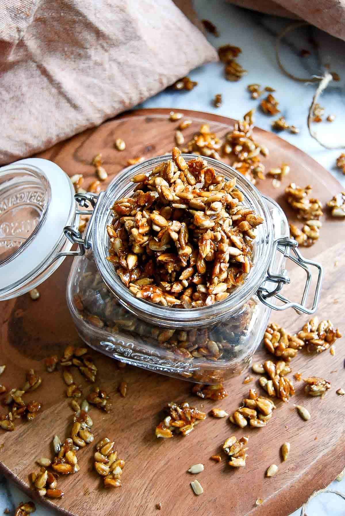 closeup of honey coated sunflower seeds in jam jar.