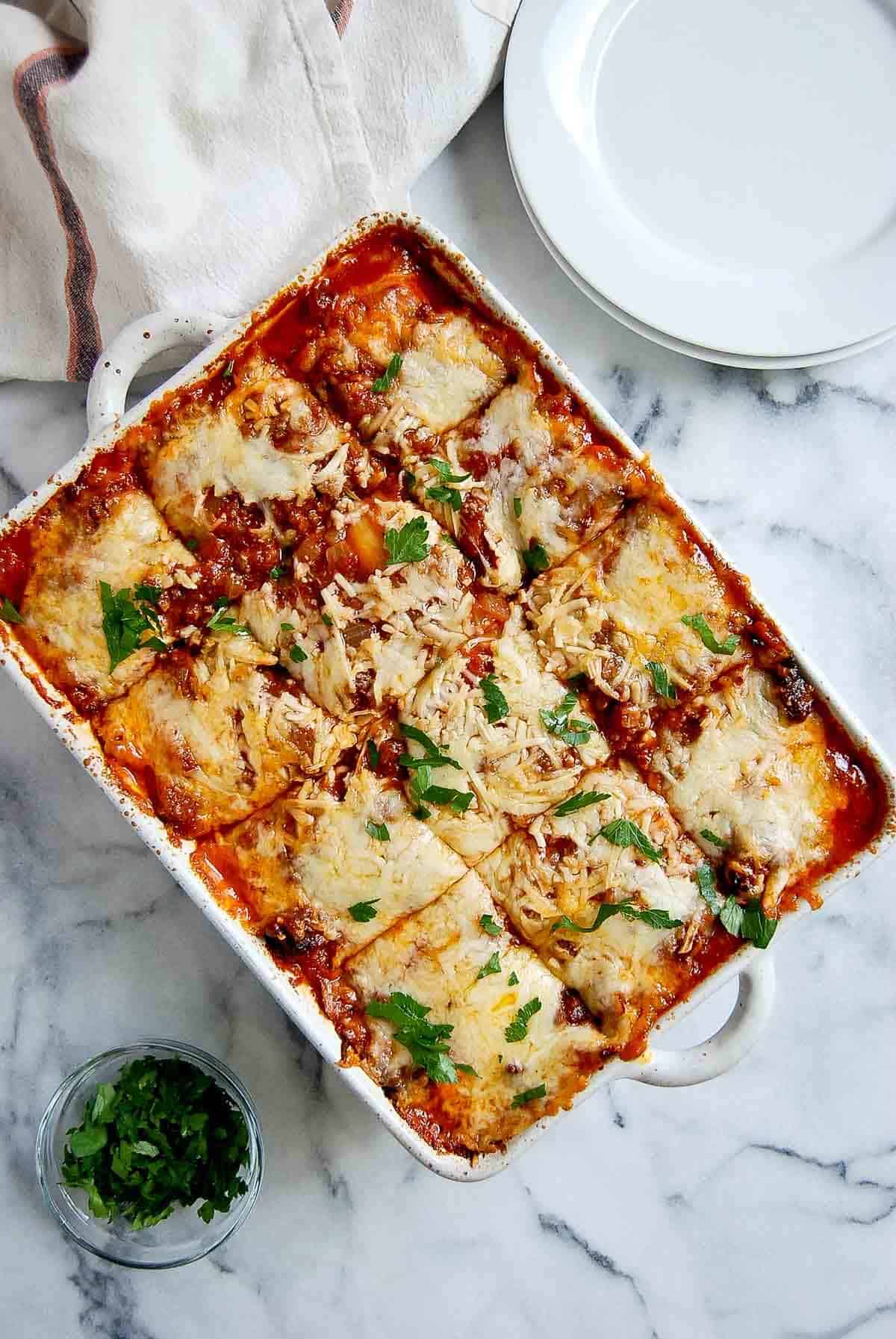 lazy ravioli lasagna in casserole dish, slices cut.