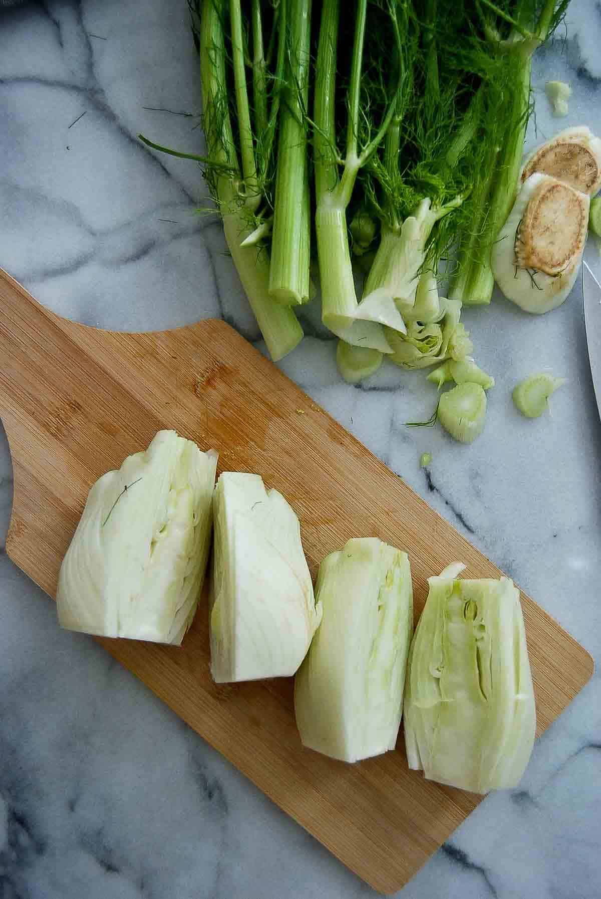 fennel bulbs, halved, on cutting board.