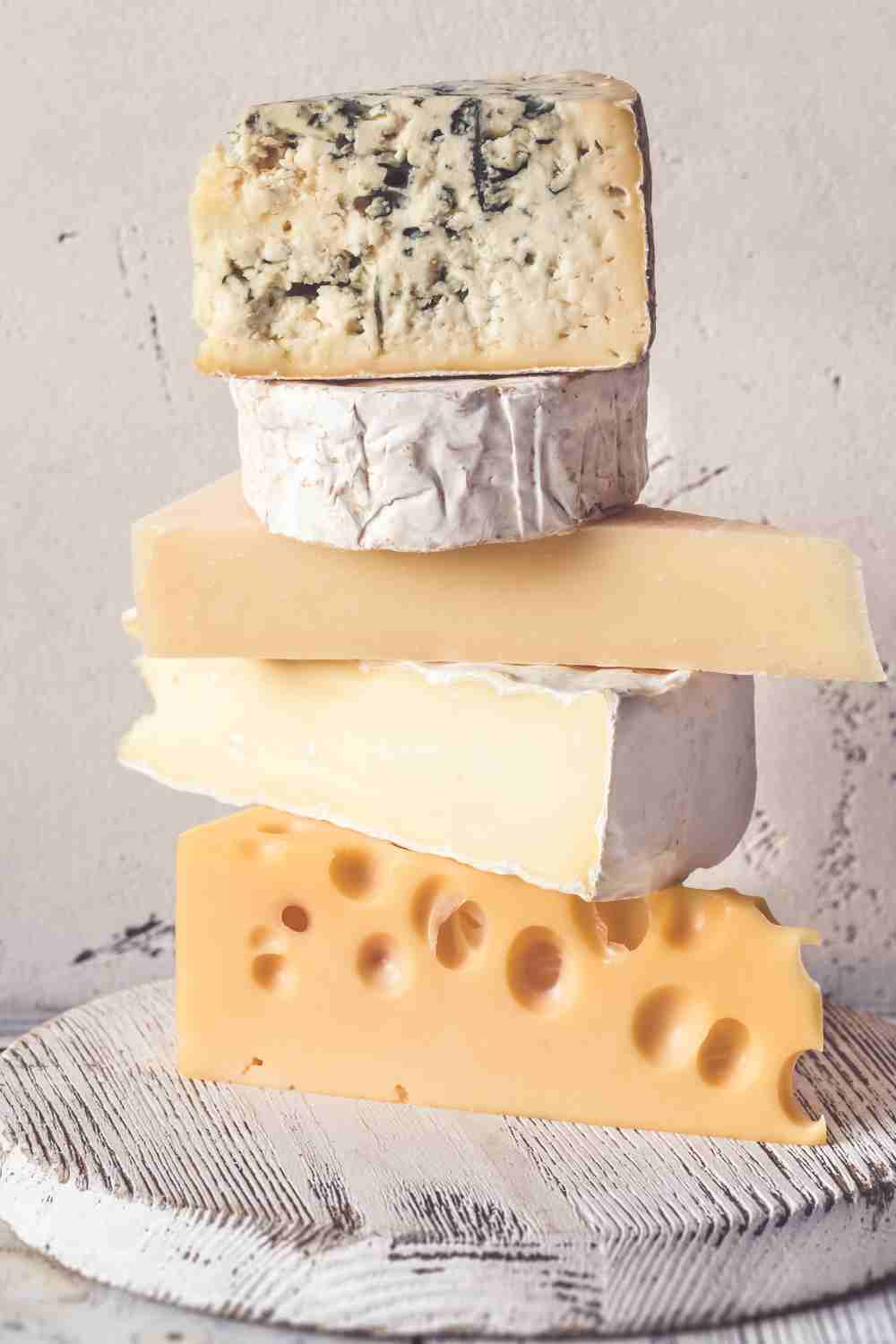 stack of cheese on cutting board.