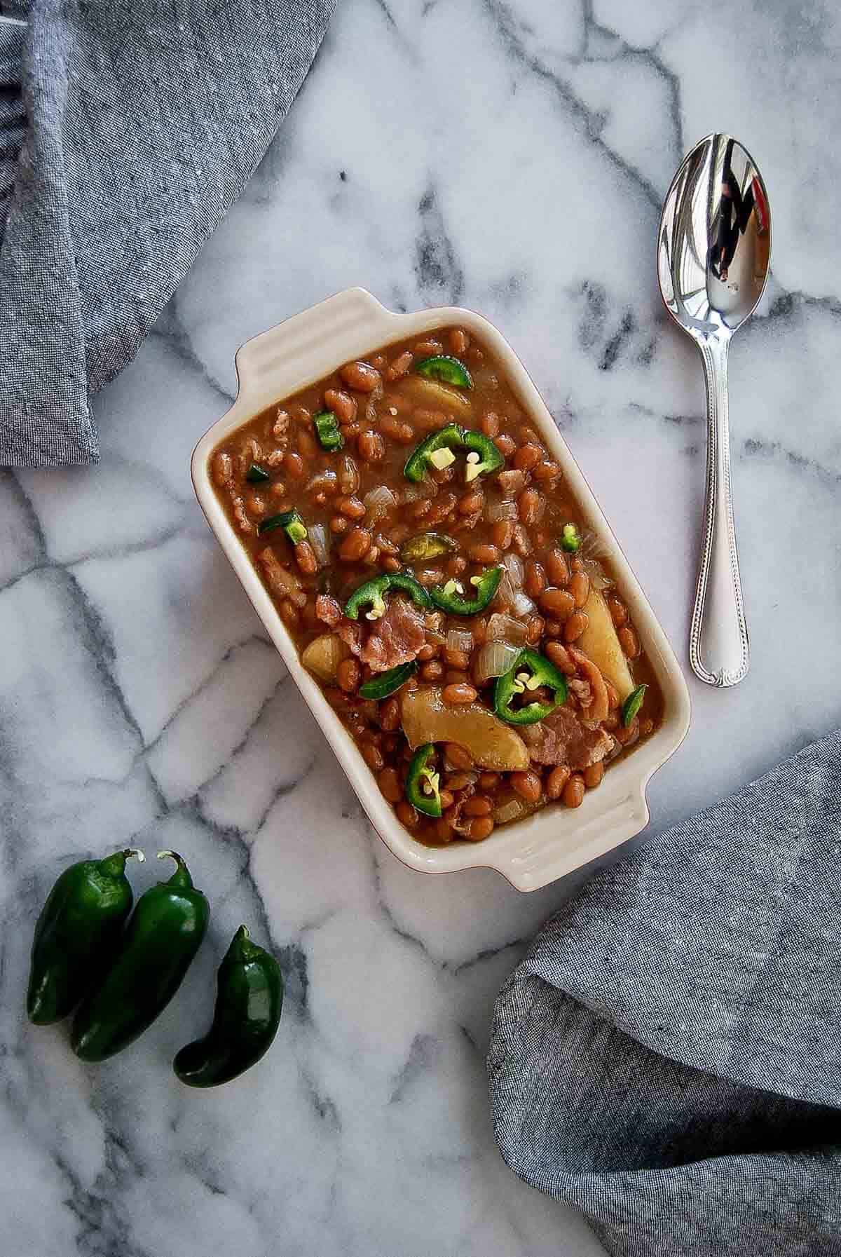 apple pie baked beans in serving dish on countertop.