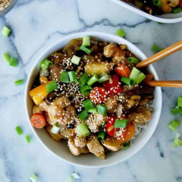 chicken and shrimp stir fry with garlic ginger sauce in bowl.