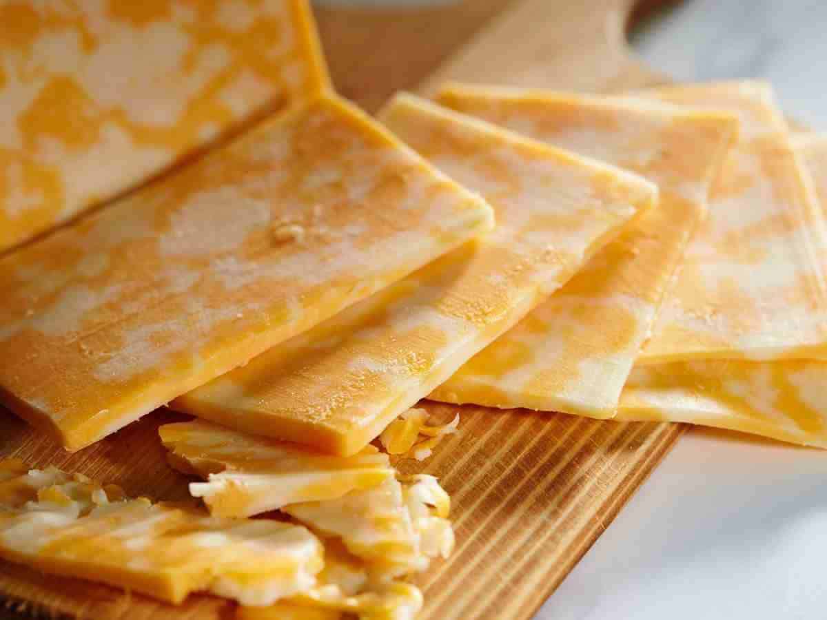 slices of colby cheese on cutting board.