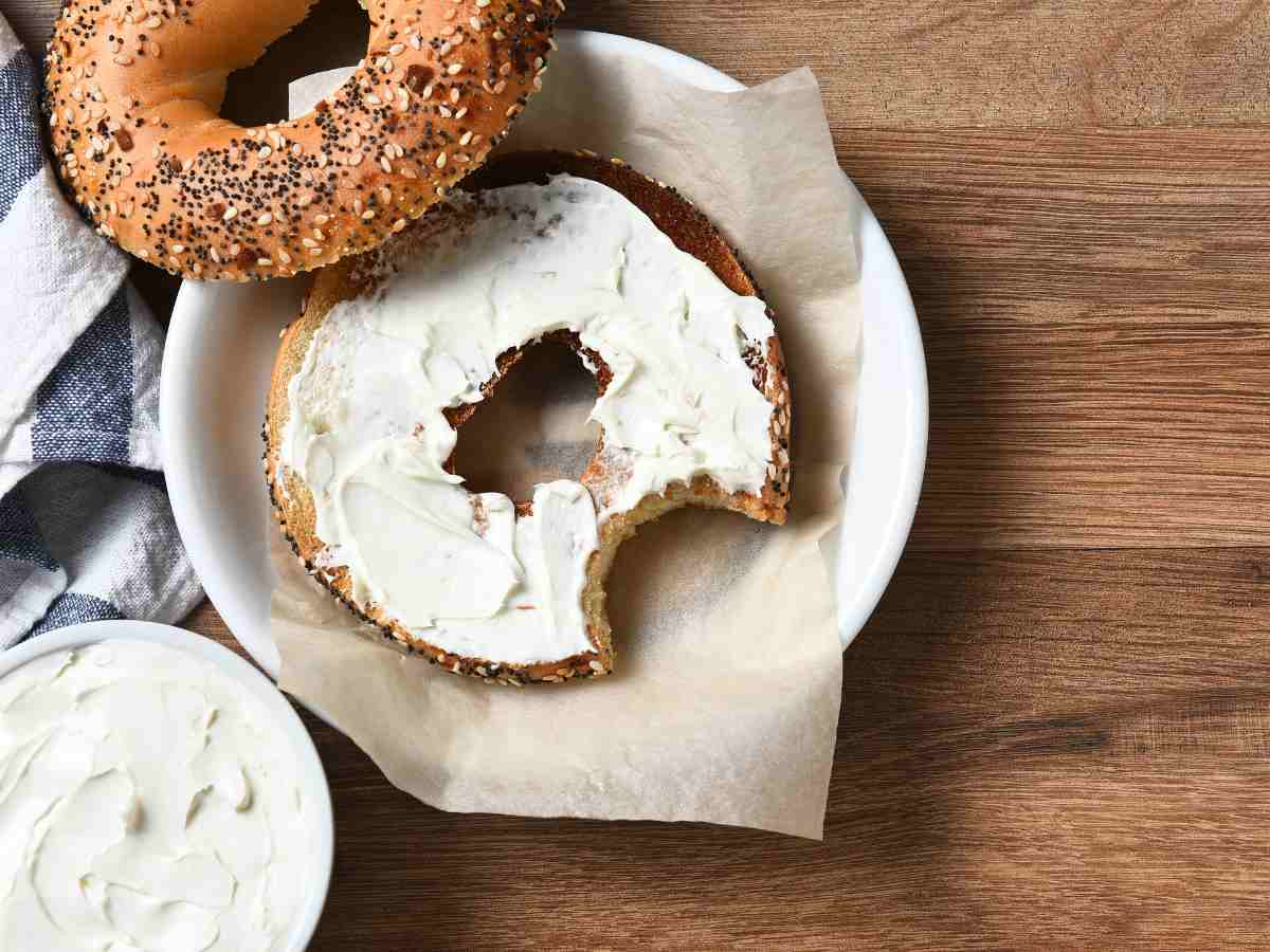 cream cheese spread on bagel, on top of plate.