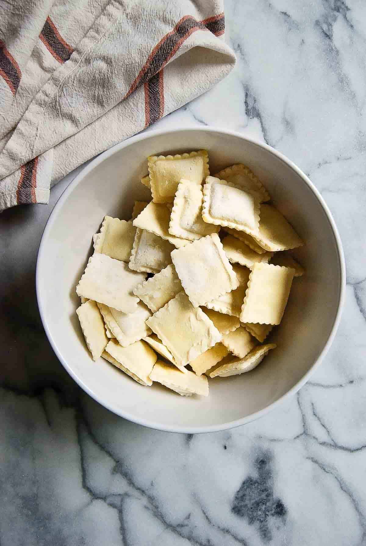 bowl of frozen cheese ravioli on countertop.