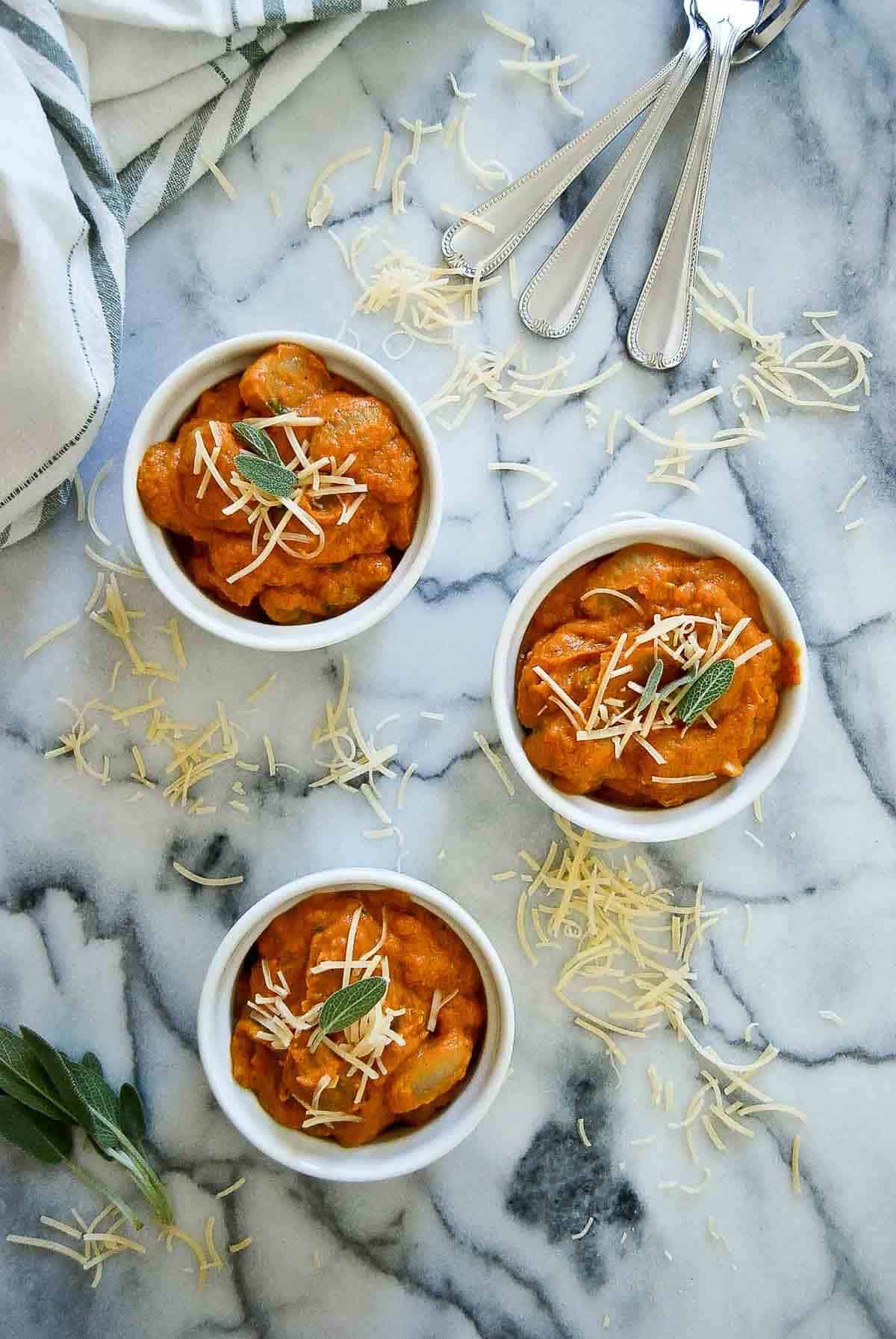 3 bowls of pumpkin gnocchi sauce with parmesan and sage.