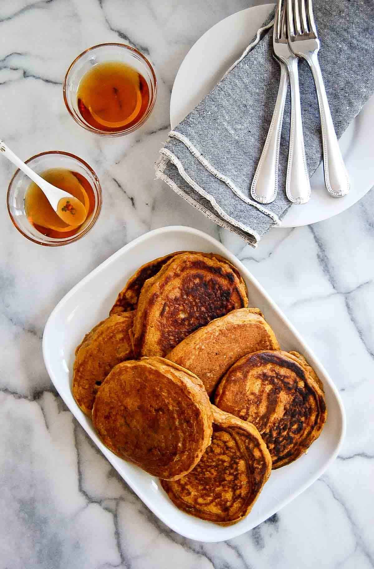 platter of pumpkin pancakes from pancake mix with maple syrup on the side.