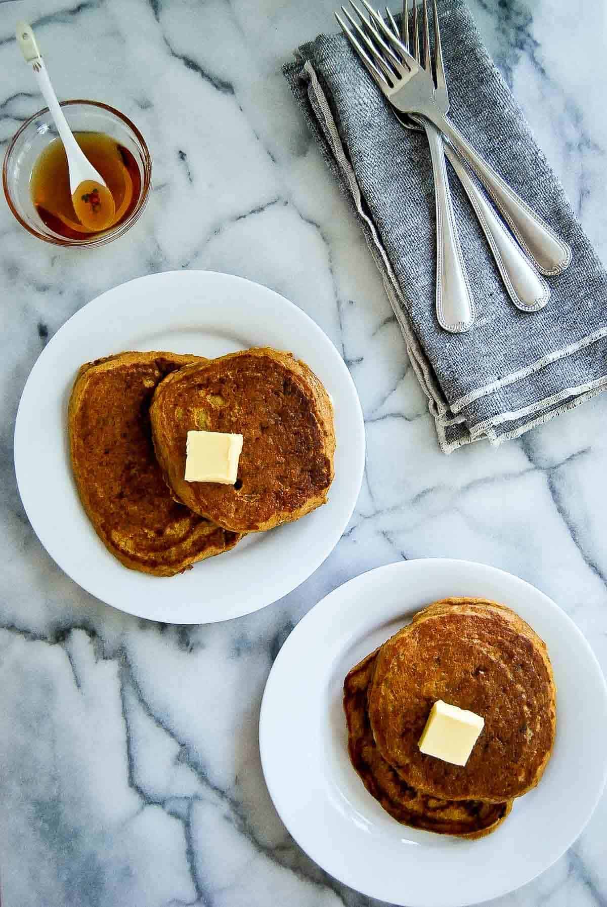 plated pumpkin pancakes with tabs of butter on the top.