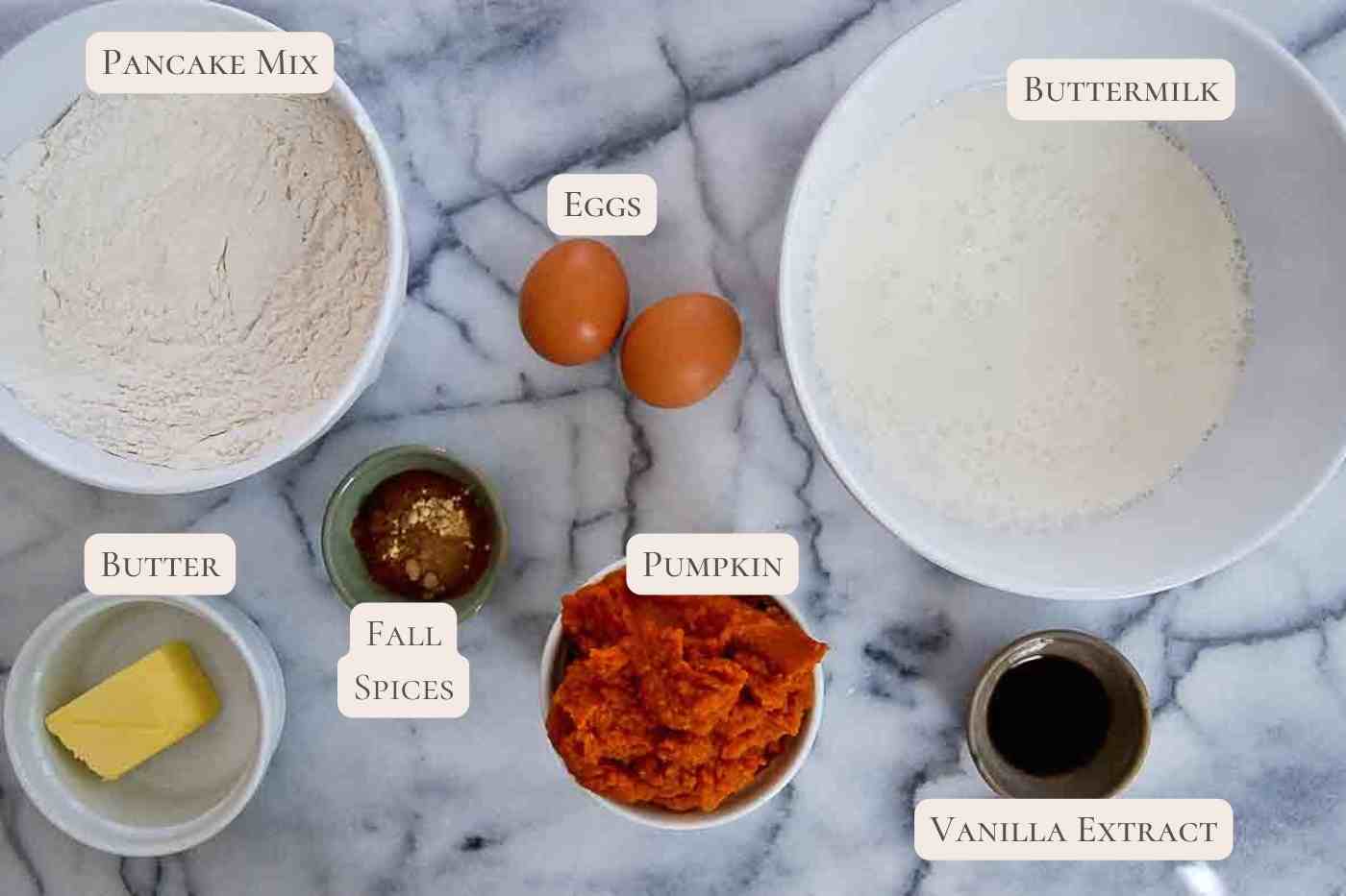 ingredients for pumpkin pancakes with pancake mix on cutting board.