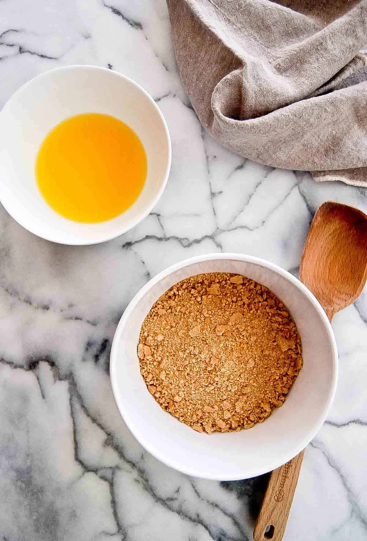 crumbled graham crackers with melted butter on countertop.