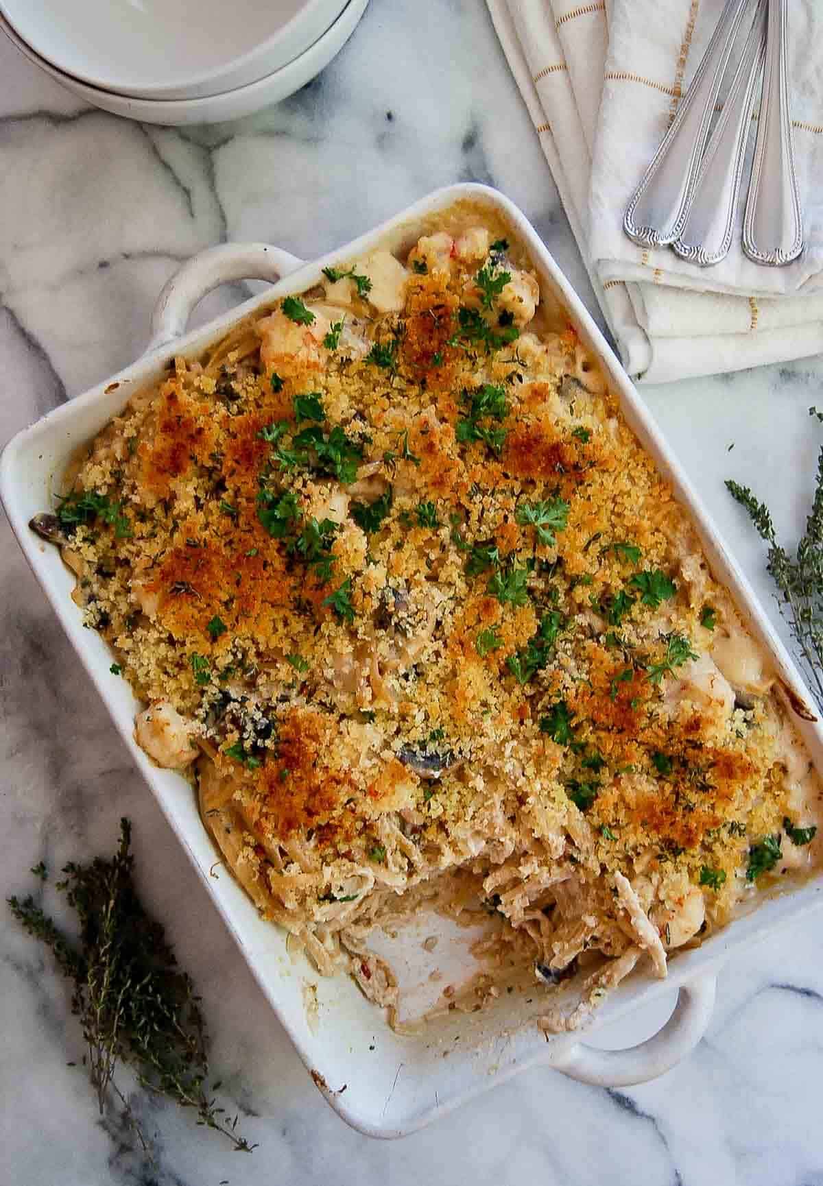 seafood tetrazzini casserole on countertop with one piece scooped out.