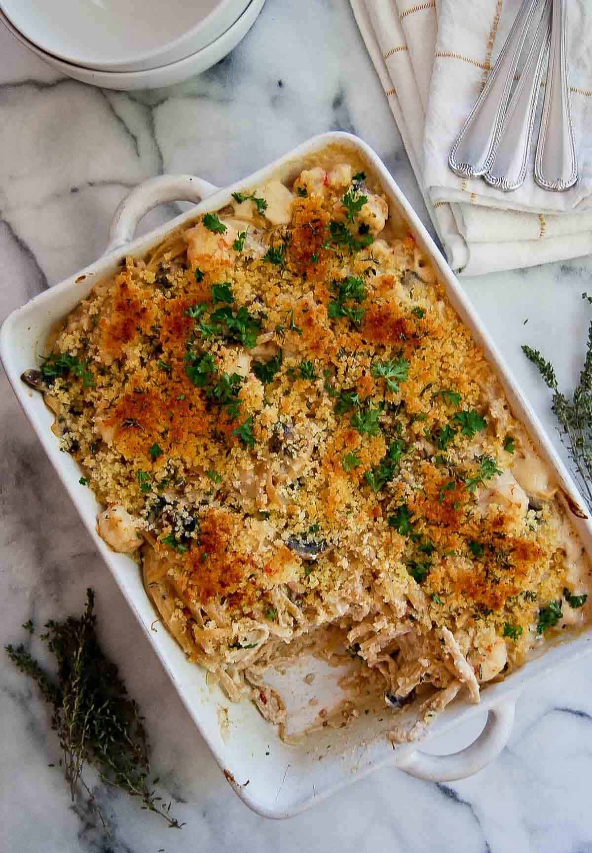 seafood tetrazzini casserole on countertop with one piece scooped out.