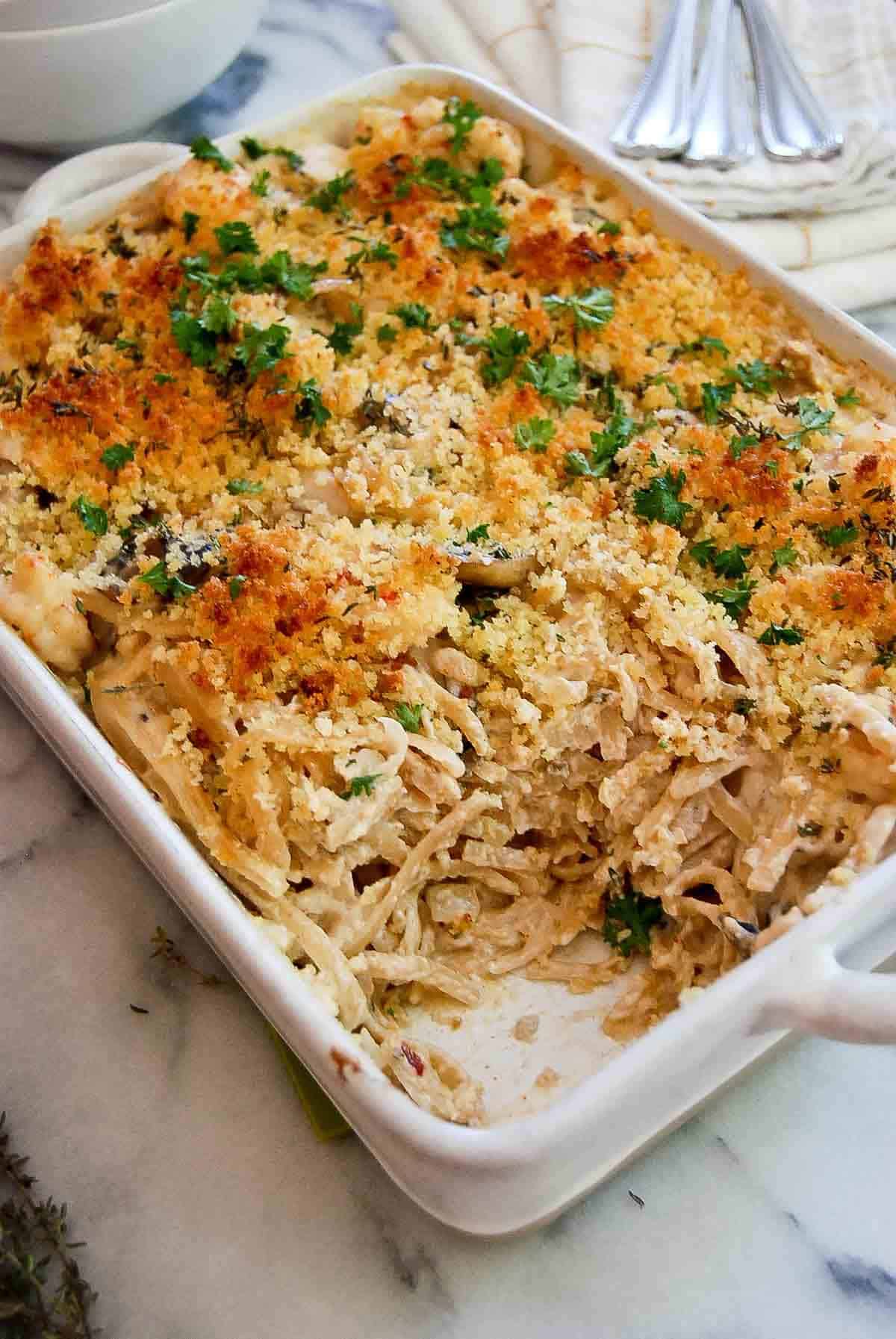 seafood tetrazzini casserole on countertop, with one serving removed.