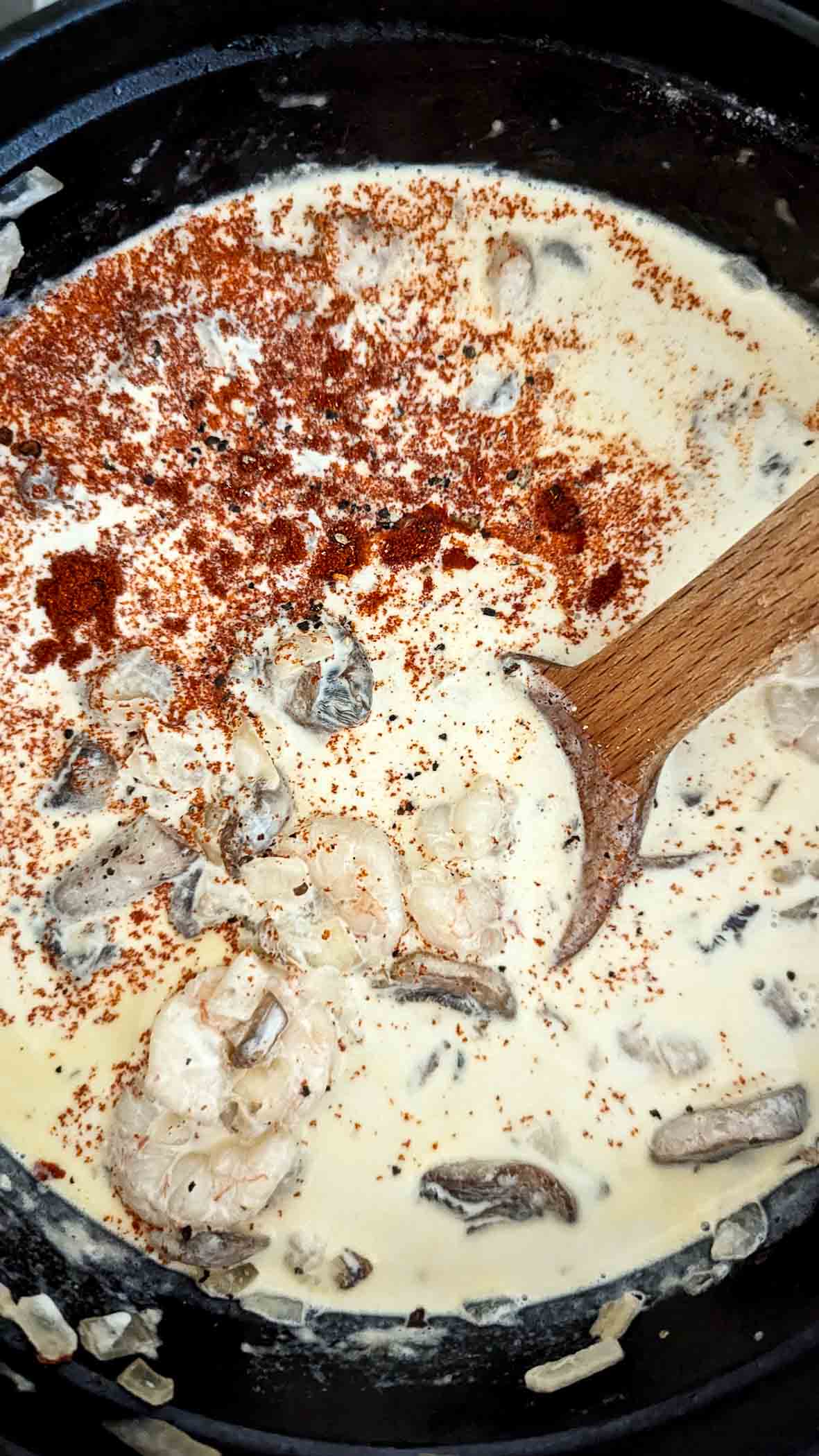 cream shrimp pasta sauce simmering on stovetop.