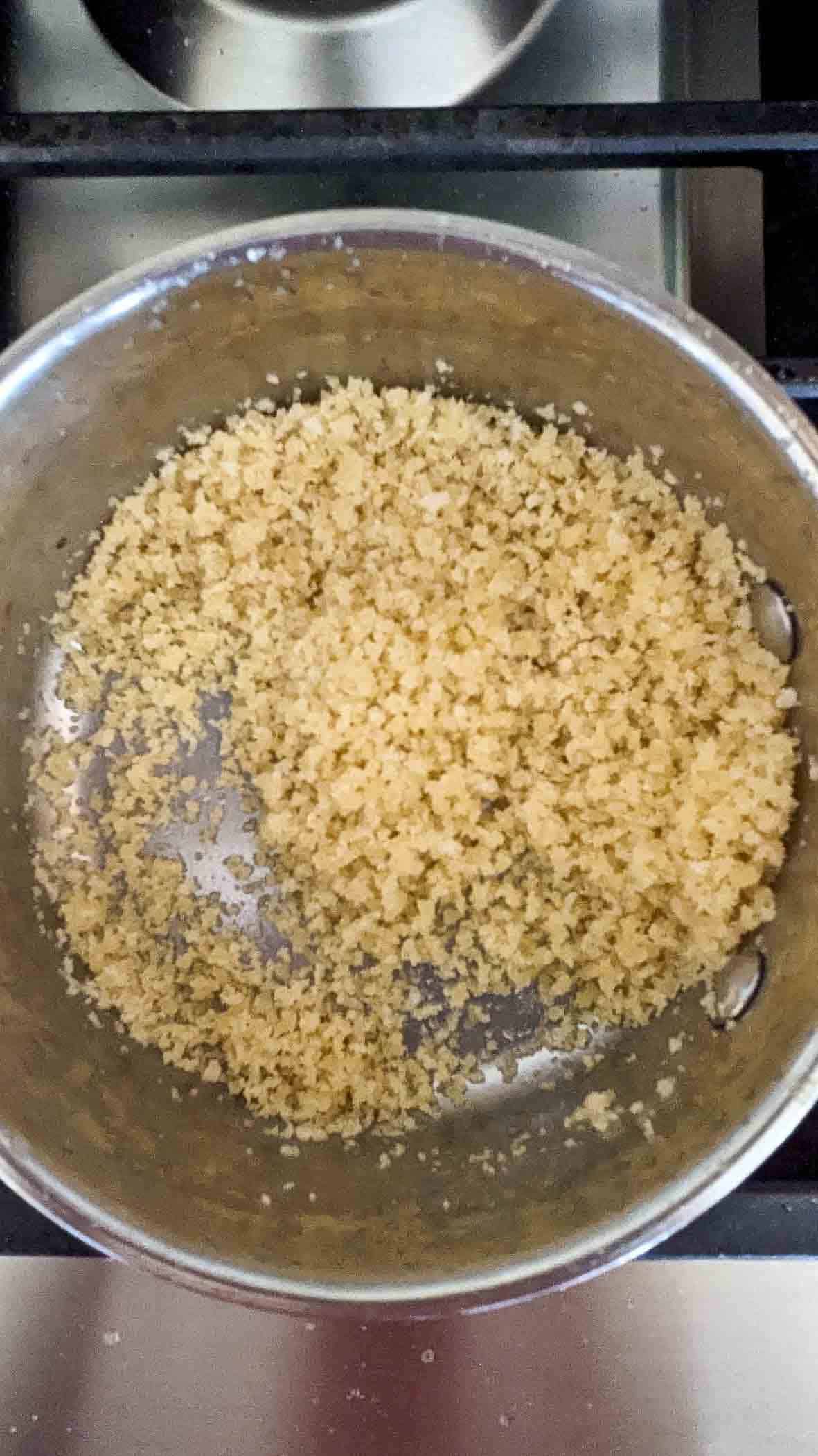 panko breadcrumbs mixed with butter on stovetop.