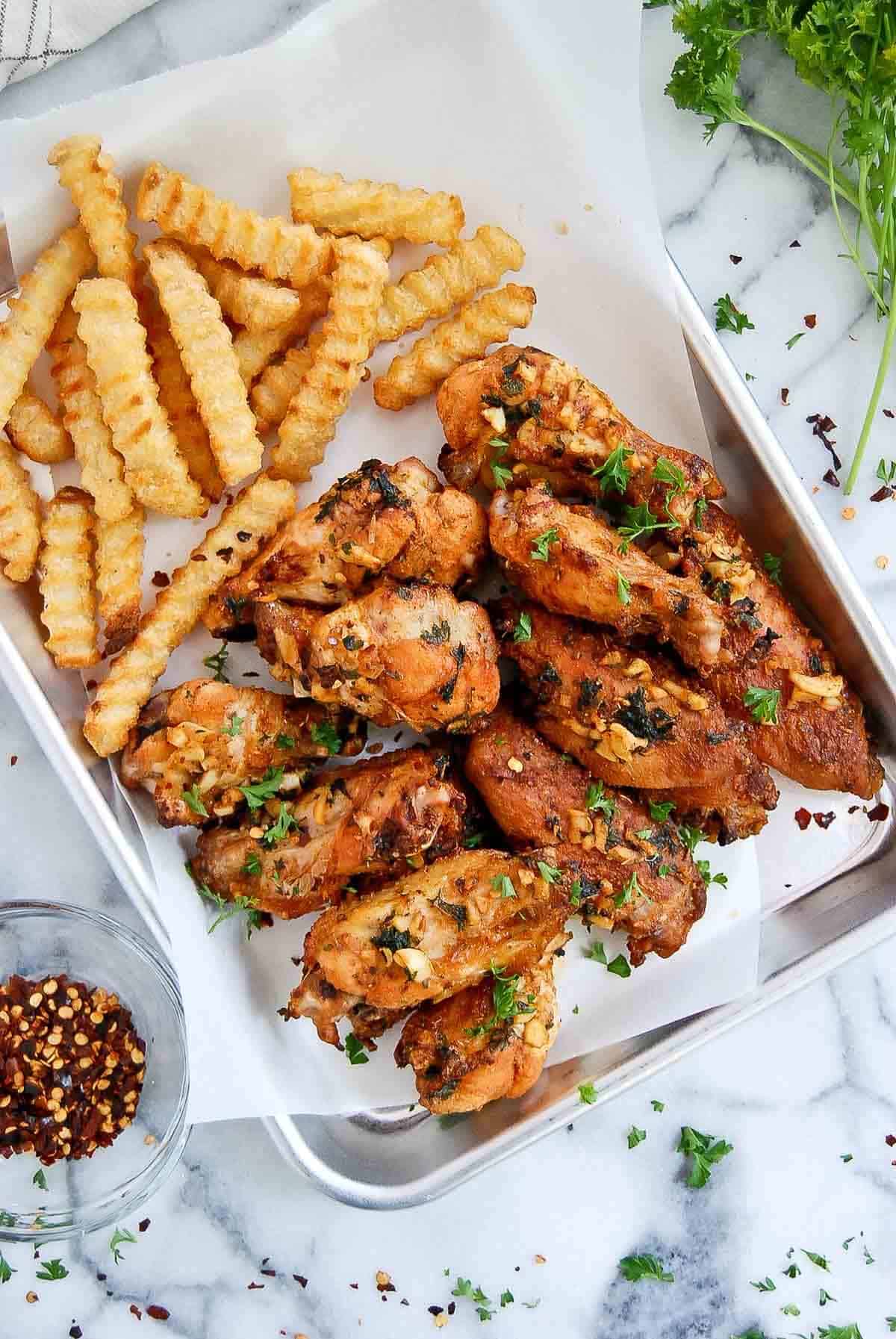 spanish chicken wings with french fries on tray.