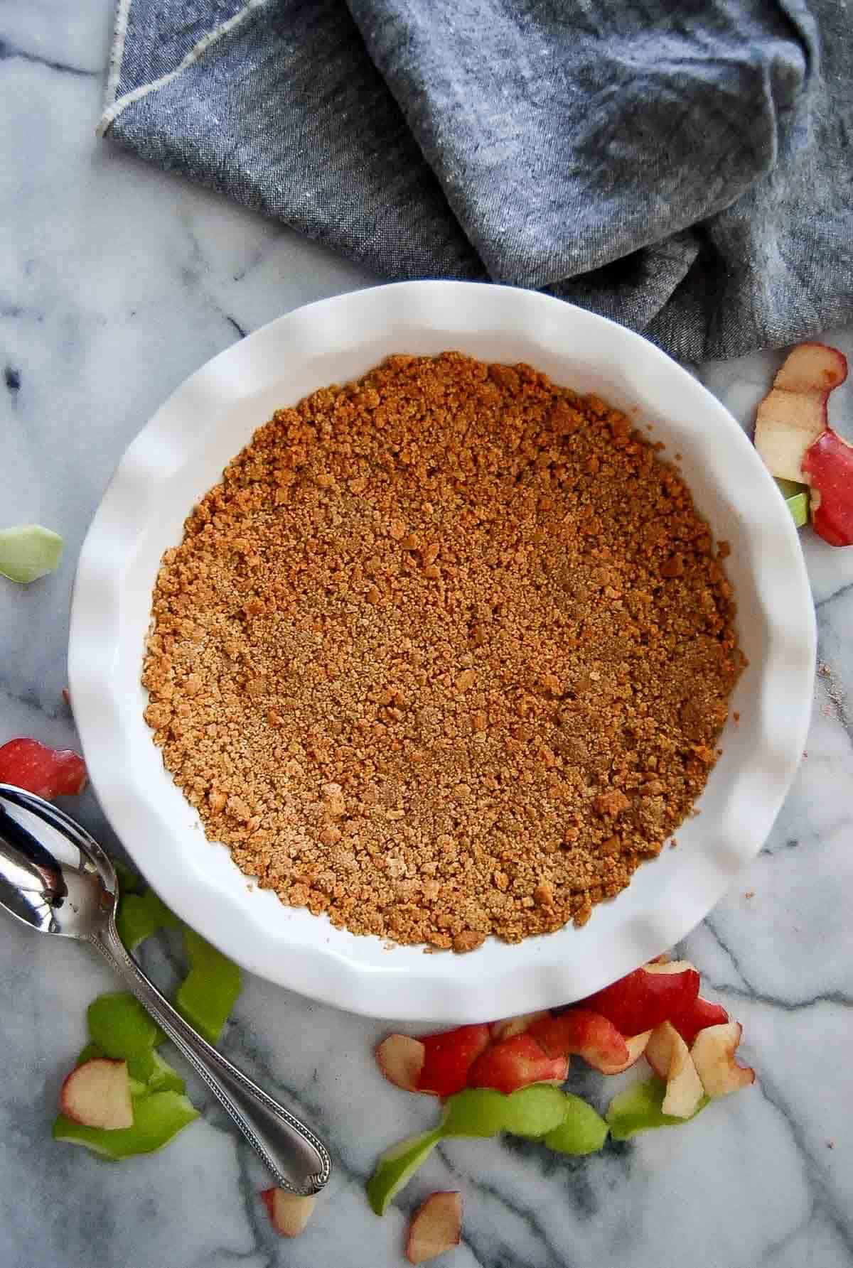 baked graham cracker crust in pie plate on counter.