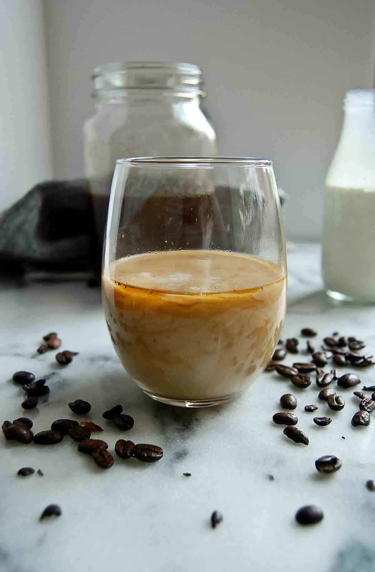 strained cold brew coffee in cup with half n half.